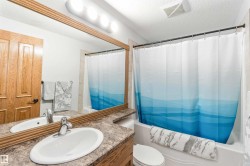 Bathroom featuring a vanity with a countertop, a single sink, and a large mirror with a wooden frame - 