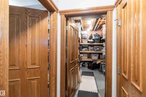 The property features wooden doors and door frames, with a practical storage area visible - 61 Linkside Blvd, Spruce Grove, AB 