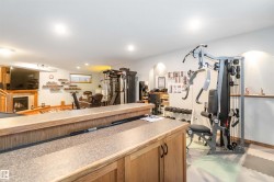 The property features a finished entertainment space with a fireplace, recessed lighting, and a window - 