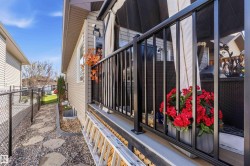Exterior siding with a black metal railing and a stone paver pathway - 