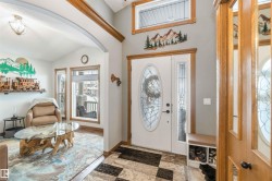 The entrance features a white door with an oval-shaped leaded glass insert, complemented by a sidelight with a similar design - 
