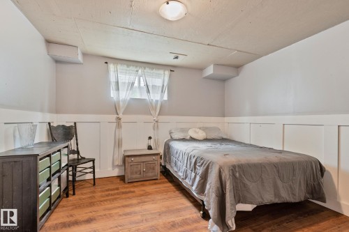Room featuring wood-finish flooring and a white board and batten wainscoting - 5161 54 Avenue, Redwater, AB - Indoor Photo Showing Bedroom