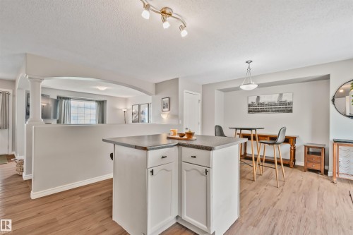 Kitchen island with white cabinetry and dark countertops - 5161 54 Avenue, Redwater, AB - Indoor