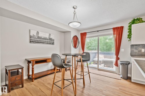 Dining area featuring wood-finish flooring and a sliding glass patio door - 5161 54 Avenue, Redwater, AB - Indoor
