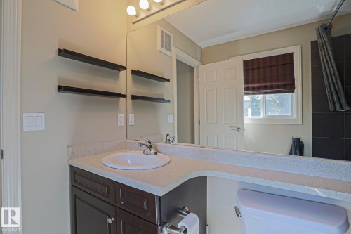 Bathroom vanity featuring a white oval sink, chrome faucet, and integrated countertop - 6215 60 Street, Beaumont, AB - Indoor Photo Showing Bathroom