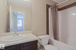 Bathroom featuring a vanity with an integrated sink, chrome faucet, and a dark wood-finish cabinet - 