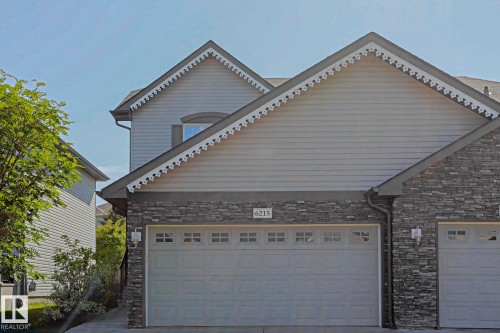 Attached two-car garage featuring panel doors with upper window inserts - 6215 60 Street, Beaumont, AB - Outdoor