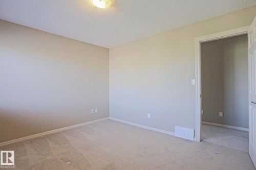 Neutral-toned wall paint and textured ceiling - 6215 60 Street, Beaumont, AB - Indoor Photo Showing Other Room