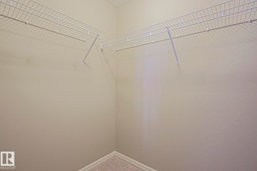 Corner closet featuring wire shelving and carpet flooring - 6215 60 Street, Beaumont, AB - Indoor With Storage