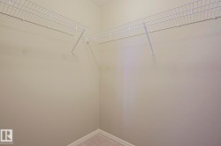 Corner closet featuring wire shelving and carpet flooring - 