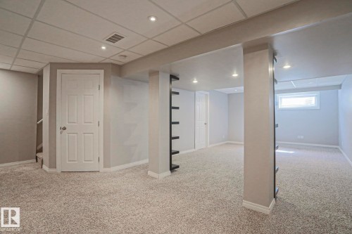 Expansive carpeted area featuring recessed lighting, a drop ceiling, and neutral wall tones - 6215 60 Street, Beaumont, AB - Indoor