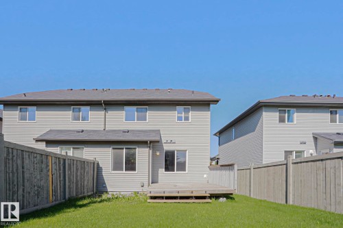 Backyard featuring a green lawn, wood fence, and a wooden deck - 6215 60 Street, Beaumont, AB - Outdoor With Exterior