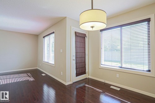 Interior space featuring wood-finish flooring, light-toned walls, and white trim - 6215 60 Street, Beaumont, AB - Indoor Photo Showing Other Room