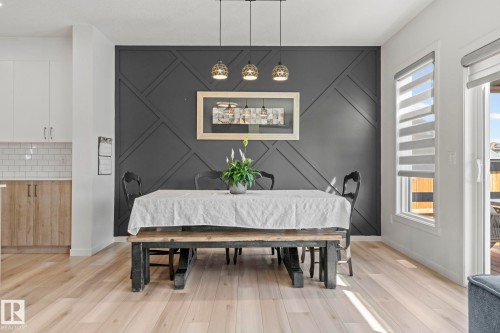 Dining area featuring a geometric accent wall and modern pendant lighting - 1931 Westerra Lane, Stony Plain, AB 