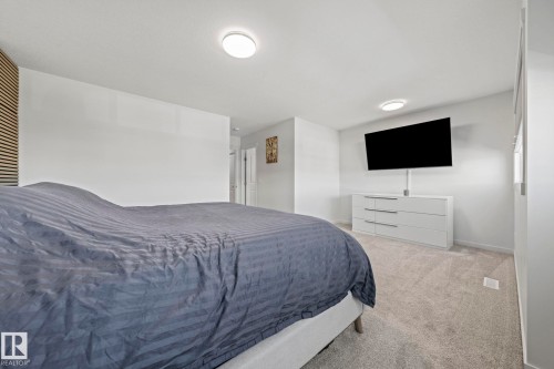 Plush carpeting throughout, white walls, and two ceiling-mounted light fixtures illuminate this expansive space - 1931 Westerra Lane, Stony Plain, AB 