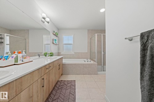 Bathroom featuring a double vanity with wood-finish cabinetry, white countertops, and dual undermount sinks - 1931 Westerra Lane, Stony Plain, AB 