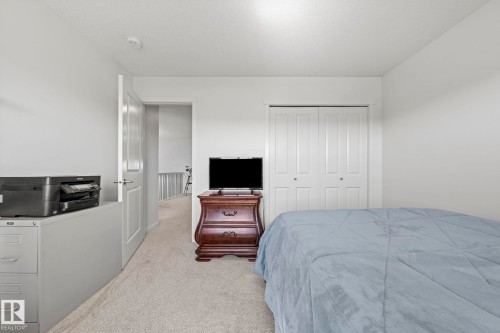 Carpeted room featuring white walls, a white paneled door, and a closet with bifold doors - 1931 Westerra Lane, Stony Plain, AB 