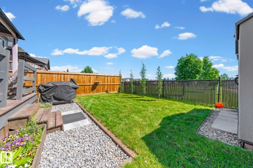 Expansive green lawn framed by a wooden privacy fence and black metal fencing - 1931 Westerra Lane, Stony Plain, AB 