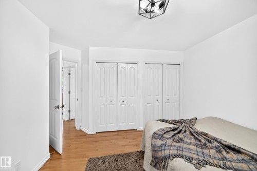 Bedroom with wood-finish flooring and a geometric ceiling light fixture - 10323 138 Street, Edmonton, AB 