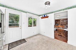 Eat-in kitchen featuring durable tile flooring and abundant natural light from the glass-panel door and window - 