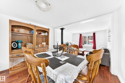 Dining area featuring wood-finish flooring, a built-in wooden hutch with shelving and drawers, and an overhead flush-mount light fixture - 191 Ridgewood Terrace, St. Albert, AB 
