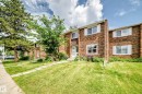 Brick exterior featuring white window frames and shutters, two levels of living space, a front entry with a small porch, a lawn, and mature trees - 191 Ridgewood Terrace, St. Albert, AB 
