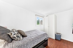 Bright room with wood-finish flooring and a white built-in wardrobe - 