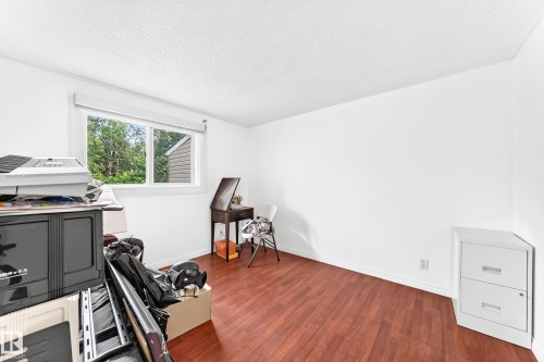 Room featuring rich wood-finish flooring, white painted walls, and a large window with white trim - 191 Ridgewood Terrace, St. Albert, AB 