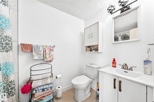 Bathroom featuring a white vanity with integrated sink, brushed nickel faucet, and coordinating mirror - 191 Ridgewood Terrace, St. Albert, AB 