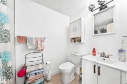 Bathroom featuring a white vanity with integrated sink, brushed nickel faucet, and coordinating mirror - 