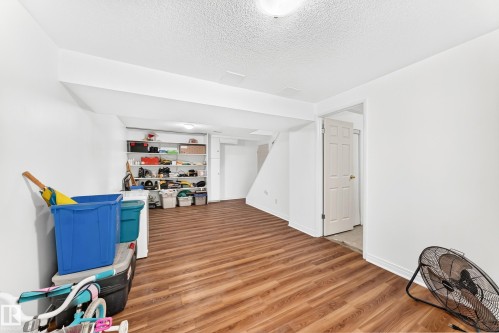 Finished basement space featuring wood-finish flooring, white walls, and built-in shelving - 191 Ridgewood Terrace, St. Albert, AB 