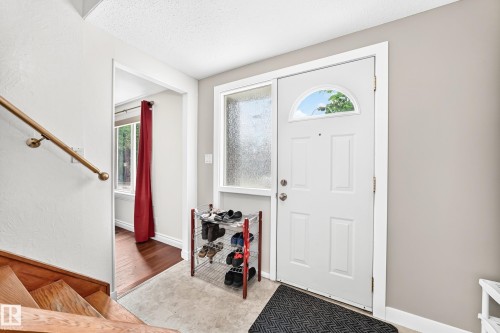 Entryway featuring a paneled white door with an arched window, a textured glass sidelight, and light gray wall paint - 191 Ridgewood Terrace, St. Albert, AB 