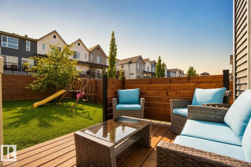 Spacious backyard deck featuring wood plank flooring and a slatted wood privacy fence - 70 James Crescent, St. Albert, AB 
