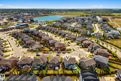 Aerial perspective of a residential neighborhood featuring a central lake - 70 James Crescent, St. Albert, AB 