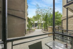 Private patio space featuring a stamped concrete surface and black metal railings with clear panel inserts - 