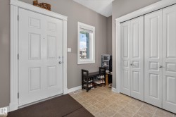 Entryway featuring light gray walls and square tile flooring - 
