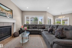 Living area featuring a fireplace with a tiled surround and white mantel, recessed lighting, and multiple windows with horizontal blinds - 