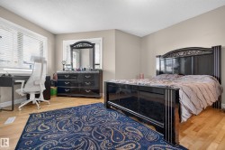 Expansive room featuring light wood-finish flooring and two large windows with blinds - 