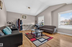 Vaulted ceilings enhance this room featuring wood-finish flooring - 