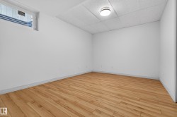 Room featuring light wood-finish flooring, white walls, and a drop ceiling with recessed lighting - 