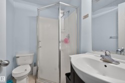 Bathroom featuring a stand-up shower with glass enclosure, single vanity with integrated sink, and wall-mounted mirror - 