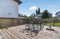 Spacious wood-plank deck with a wood privacy fence and a green lawn beyond - 