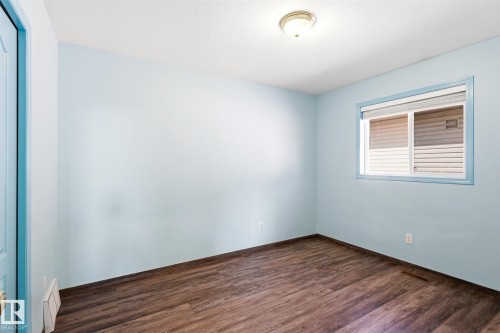 Room featuring wood-finish flooring, light blue walls, and a white ceiling - 14908 137 Street, Edmonton, AB 