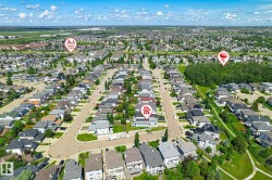 Aerial perspective showcasing a residential area with a prominent central street and numerous single-family homes - 