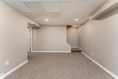 Finished room featuring recessed lighting, a drop-panel ceiling, neutral-toned carpeting, and crisp white baseboards - 16B Callingwood Court, Edmonton, AB 