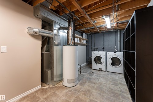 Utility area featuring a water heater, furnace, and laundry appliances - 16B Callingwood Court, Edmonton, AB 