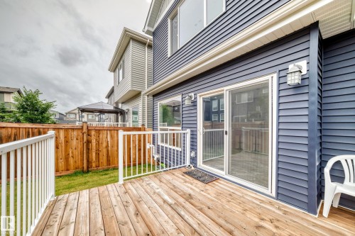 Wood-finish deck with white railings and blue siding exterior - 8710 Mayday Lane, Edmonton, AB 