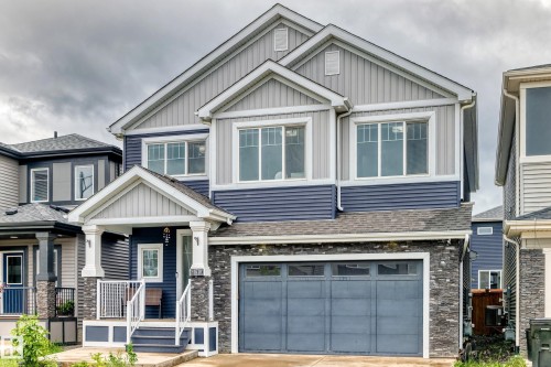 Contemporary two-story residence featuring a striking blue and gray siding facade - 8710 Mayday Lane, Edmonton, AB 