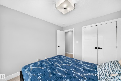 Bedroom featuring light gray walls, white trim, and light carpeting - 8710 Mayday Lane, Edmonton, AB 