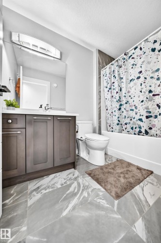 Bathroom featuring a dark wood-finish vanity with a white countertop and rectangular sink - 8710 Mayday Lane, Edmonton, AB 